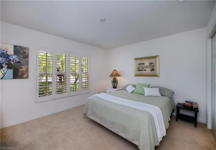 Bedroom with light carpet and baseboards