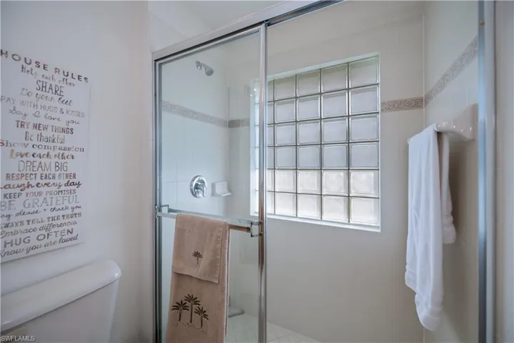 Bathroom featuring a shower stall and toilet