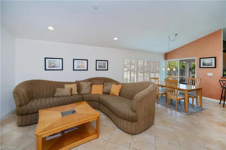 Living area featuring recessed lighting, lofted ceiling, and baseboards