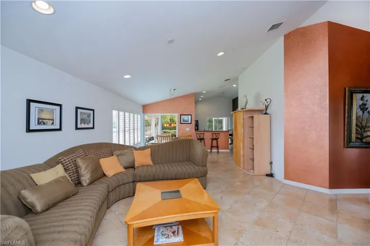 Living room featuring recessed lighting, lofted ceiling, visible vents, and baseboards