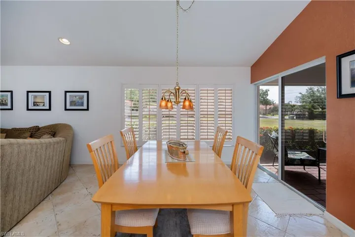 Dining room with stone tile floors, a healthy amount of sunlight, and an inviting chandelier