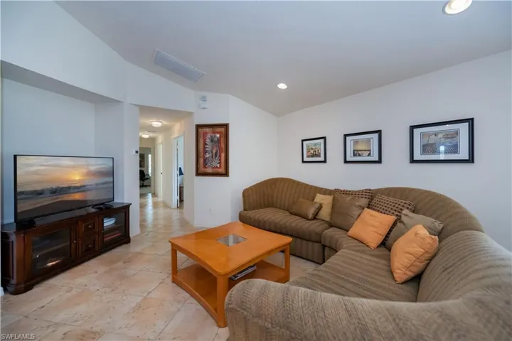 Living area with vaulted ceiling, visible vents, and recessed lighting