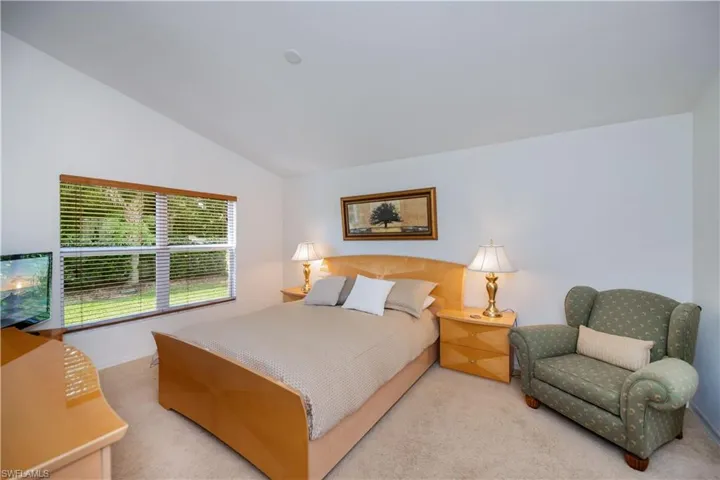 Bedroom featuring vaulted ceiling and carpet