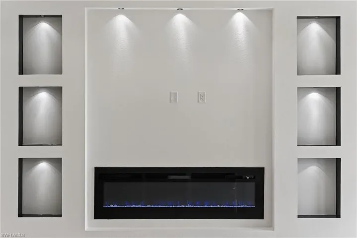 Built-in electric fireplace, integrated display niches with accent lighting, and recessed ceiling lighting