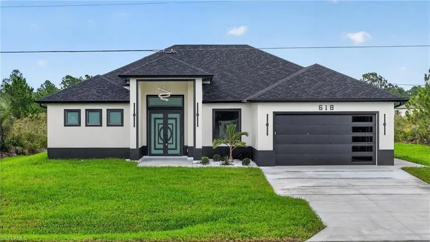 Modern single-story exterior with a dark shingle roof and light-toned stucco