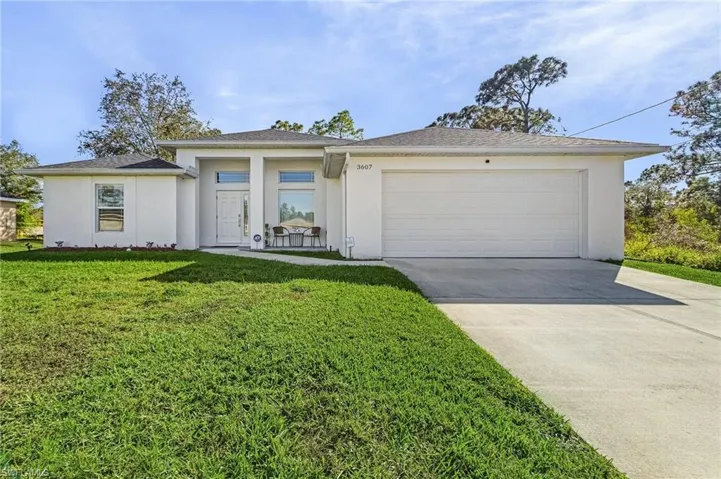 View of front of house with a garage and a front lawn