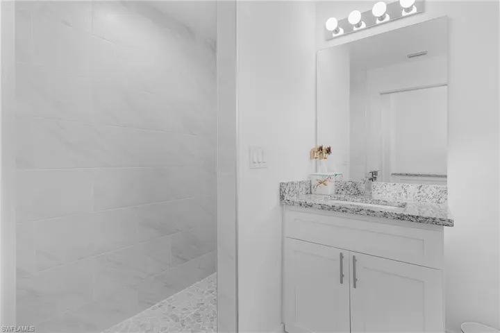 Guest Bathroom with vanity and tiled shower