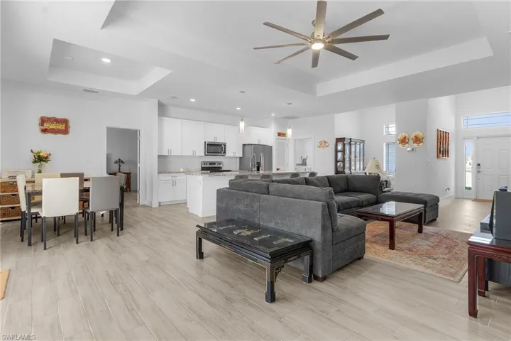 Living room featuring a tray ceiling and light hardwood / wood-style floors