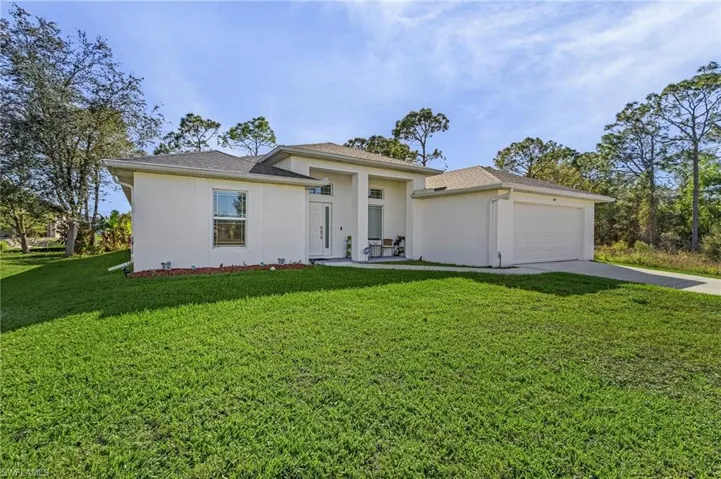 View of front of house with a garage and a front yard