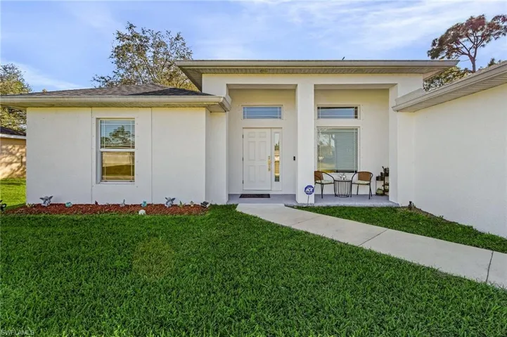 Doorway to property featuring a yard