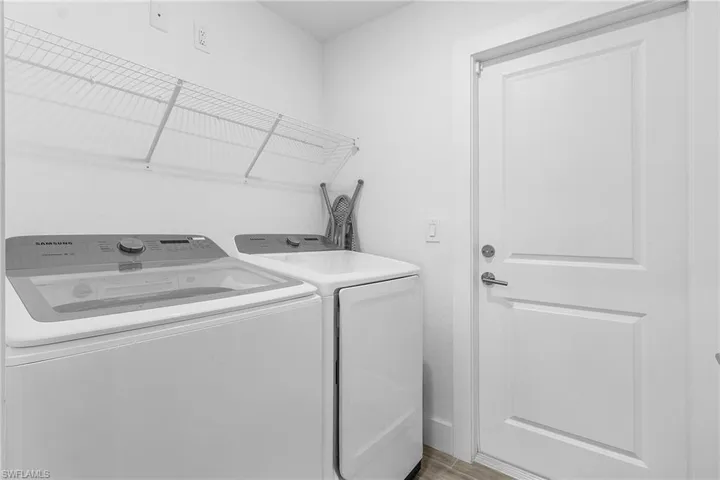 Washroom featuring washing machine and clothes dryer and light hardwood / wood-style flooring