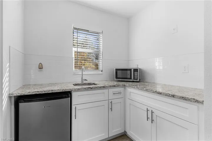 Kitchenette in Guest/inlaw bedroom with sink, stainless steel appliances, and white cabinets