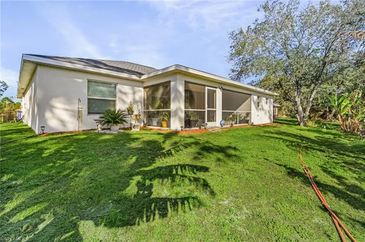 Rear view of property with a yard and a sunroom