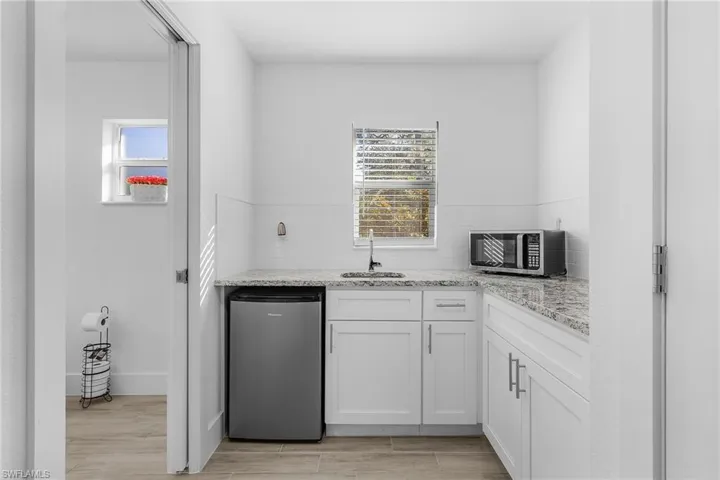 Kitchenette in Guest/inlaw bedroom with sink, stainless steel appliances, and white cabinets