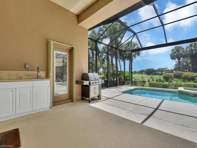 View of swimming pool with a patio area, grilling area, a lanai, and a pool with connected hot tub