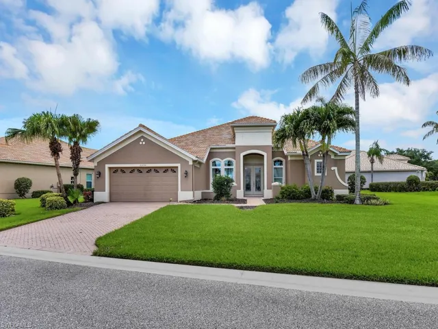 Mediterranean / spanish home with french doors, an attached garage, decorative driveway, stucco siding, and a front yard
