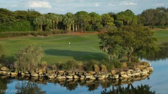 Surrounding community with golf course view, a putting green, and a water view