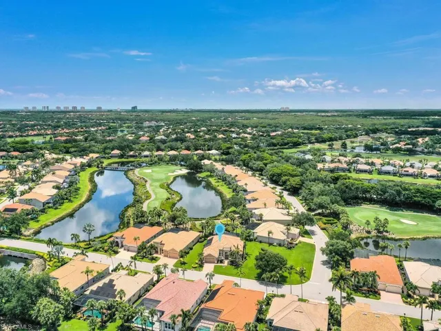 Aerial perspective of suburban area featuring a large body of water and a golf course