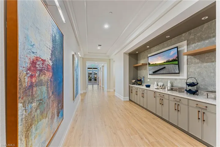 Bar featuring crown molding, light wood-style flooring, and backsplash