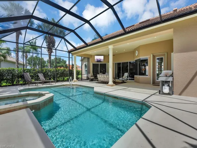 View of swimming pool featuring a patio area, a pool with connected hot tub, area for grilling, and a lanai