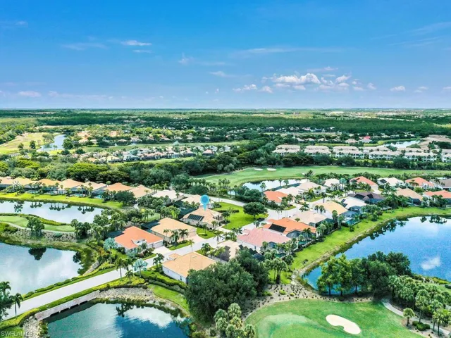 Aerial view of property and surrounding area featuring nearby suburban area and a large body of water