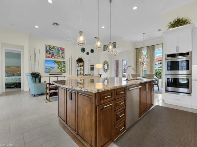 Kitchen featuring appliances with stainless steel finishes, a chandelier, recessed lighting, white cabinetry, and light stone counters