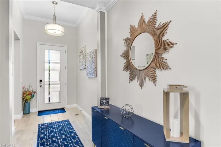 Entrance foyer with baseboards and ornamental molding