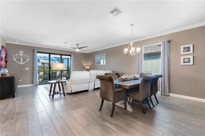 Dining space with baseboards, visible vents, light wood-style floors, and crown molding
