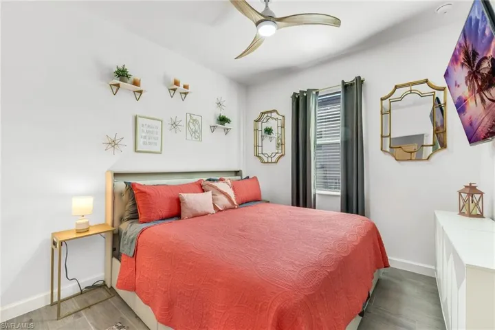 Bedroom featuring baseboards, a ceiling fan, and wood finished floors