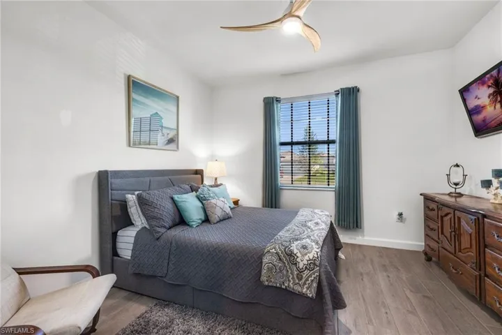 Bedroom featuring wood finished floors, a ceiling fan, and baseboards