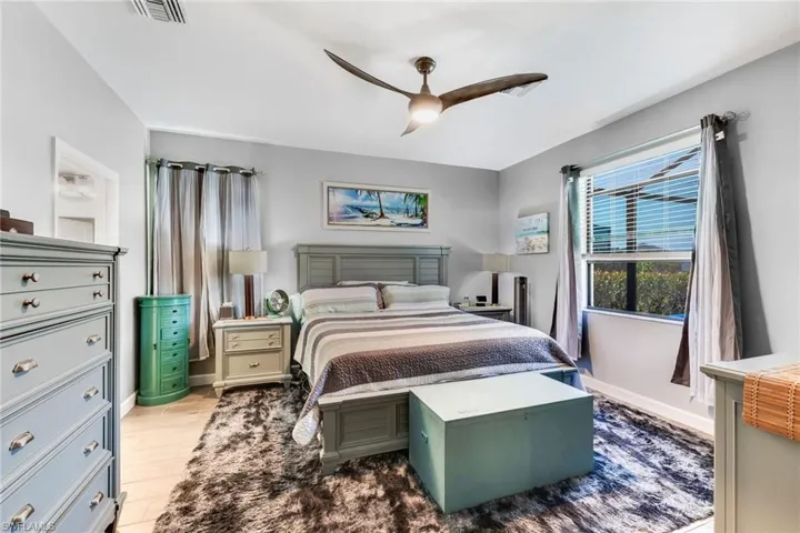 Bedroom with wood finished floors, visible vents, and ceiling fan