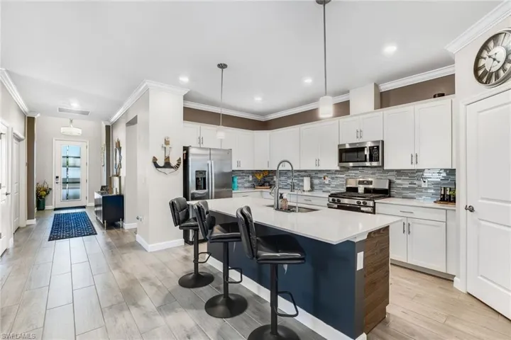 Kitchen with tasteful backsplash, a sink, light countertops, appliances with stainless steel finishes, and visible vents