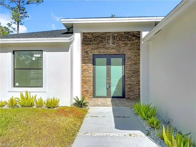 Entrance to property featuring stone siding and stucco siding