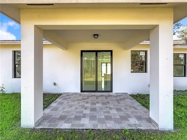 Entrance to property with a patio area and stucco siding