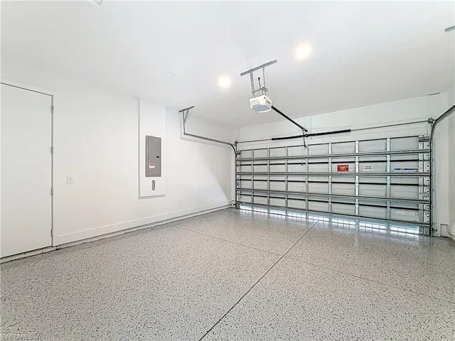 Garage with electric panel and a garage door opener