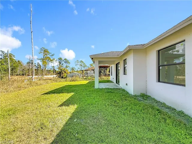 View of green lawn with a patio