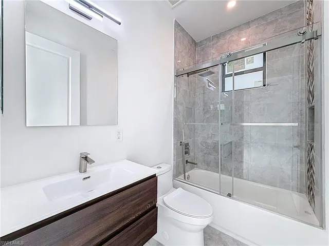 Bathroom featuring enclosed tub / shower combo and vanity