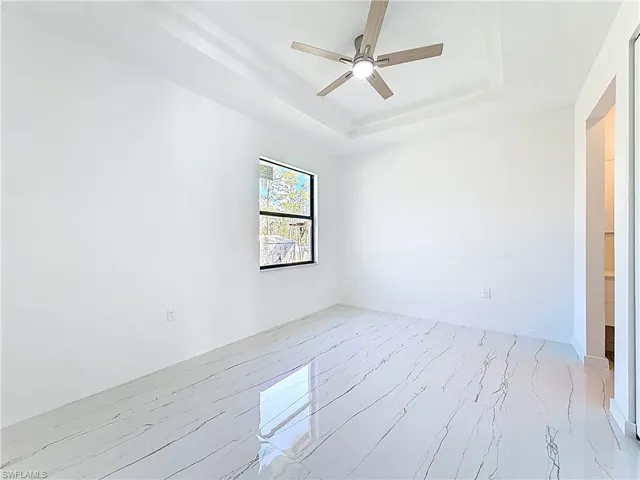 Spare room with a raised ceiling and ceiling fan