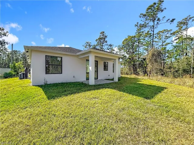 View of front of property with stucco siding, a patio, and a front lawn