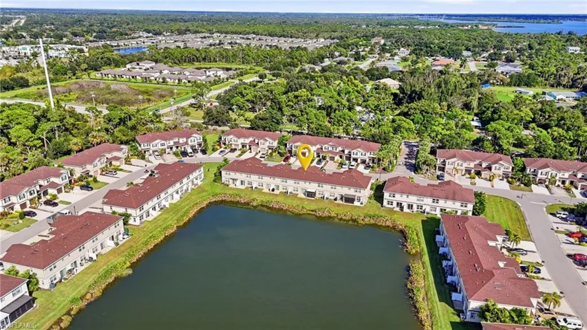 Aerial perspective of a multi-unit property featuring shingle-style roofing, exterior stucco facades, and a direct water frontage position