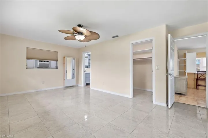 Tiled spare room featuring cooling unit and ceiling fan