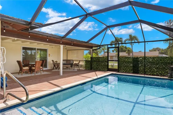 View of swimming pool featuring a patio and glass enclosure