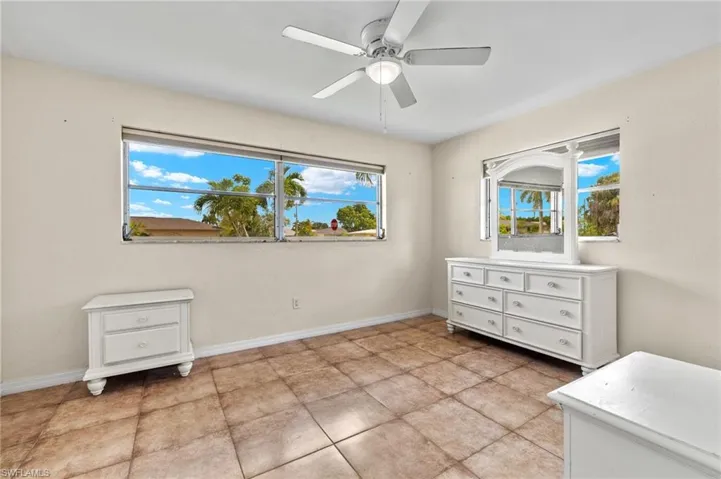 Tiled bedroom featuring ceiling fan