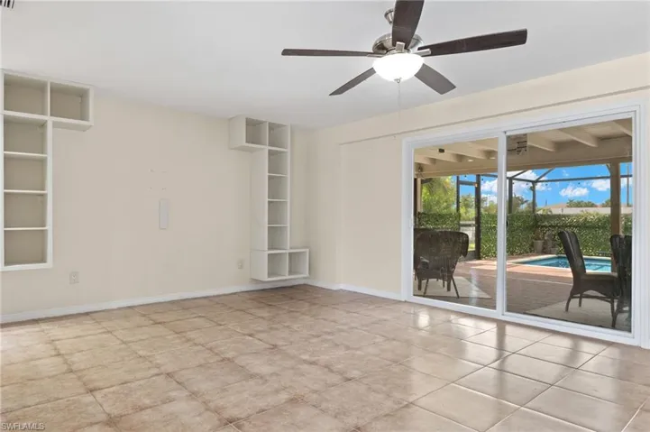 Empty room featuring light tile patterned flooring and ceiling fan