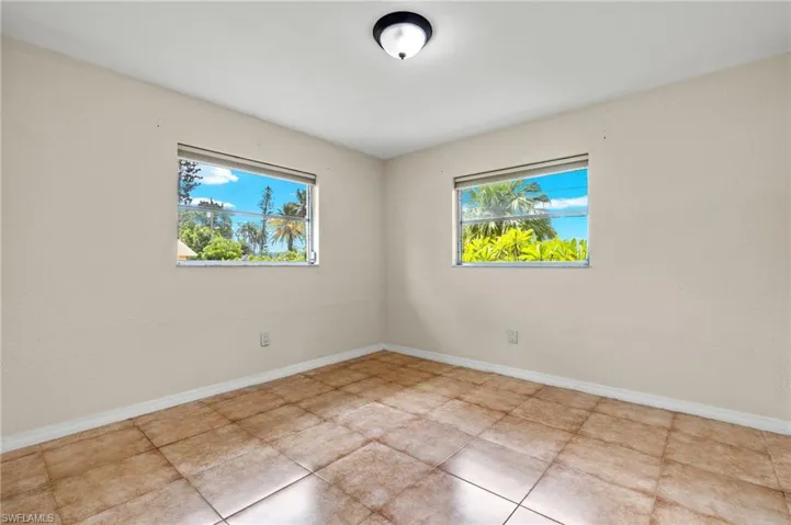 Tiled spare room featuring a wealth of natural light