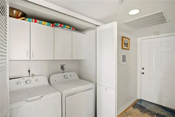 The laundry area offers cabinets for storage.