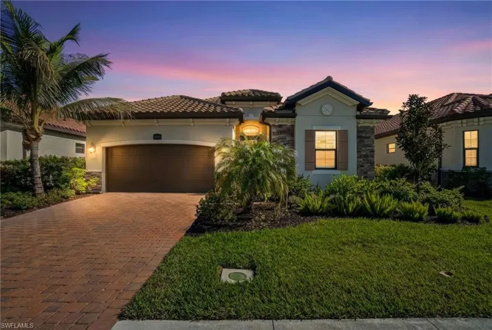 Mediterranean / spanish-style house featuring stucco siding, decorative driveway, a front lawn, an attached garage, and a tile roof