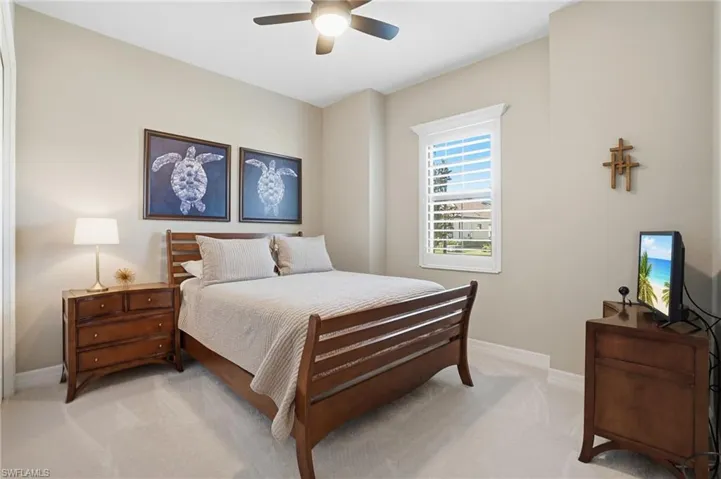 Carpeted bedroom featuring a ceiling fan and baseboards