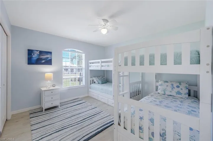 Bedroom with light hardwood / wood-style flooring, a closet, and ceiling fan