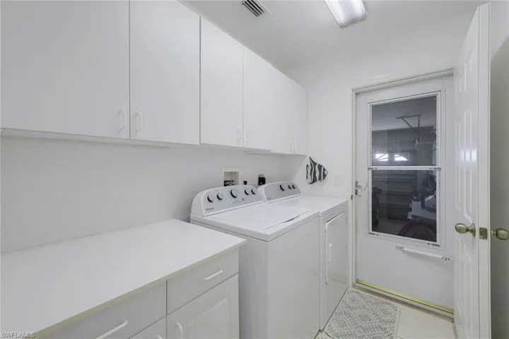 Laundry area featuring washer and clothes dryer and cabinets
